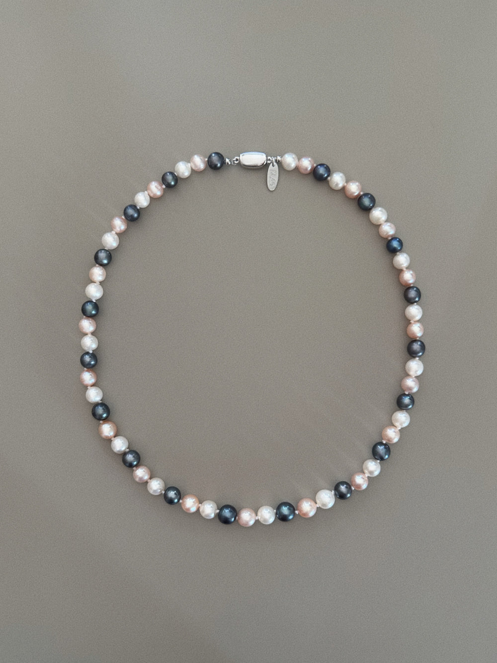 pryte Multicolor Abyss Necklace with cream, pink, and black beads on a gray background